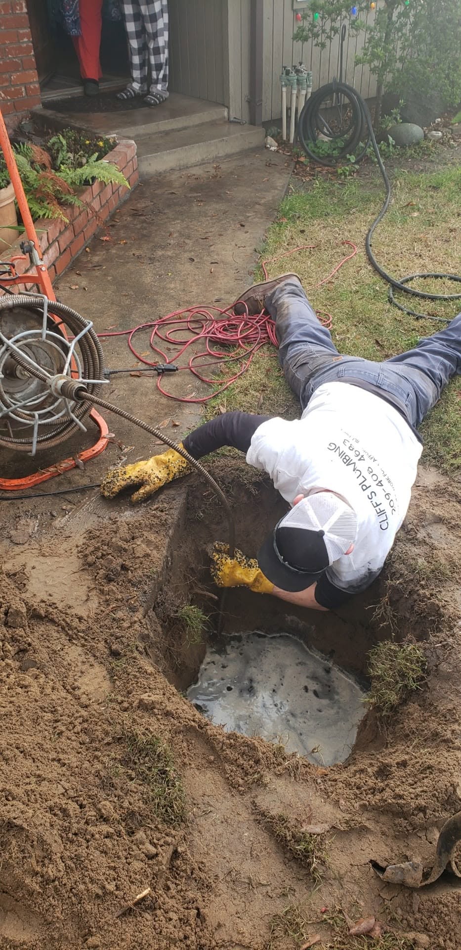 Cliff's Plumbing performing underground drain work at a local home